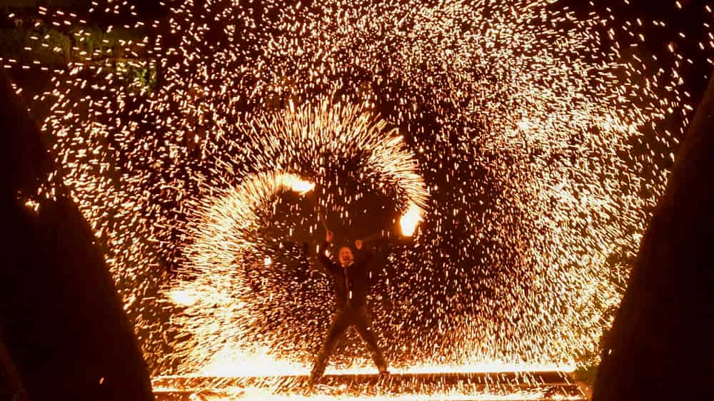 Feuerkünstler malt riesige Feuerschweife
